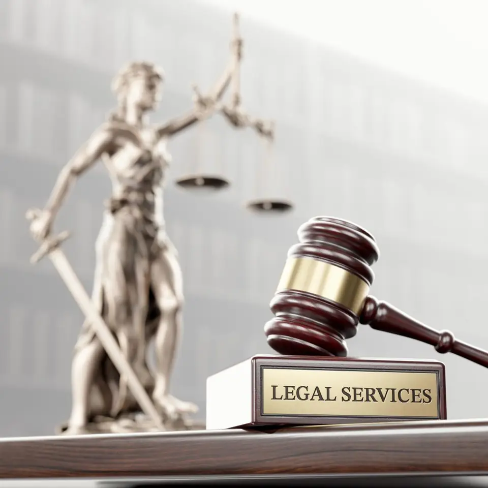 Lady Justice statue and gavel with a legal services plaque